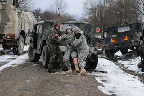 A German Army soldier and U.S. Army Soldier carrying a simulated casualty to safety