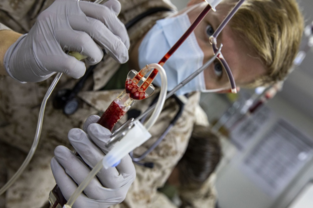 Corpsman monitors the flow of blood