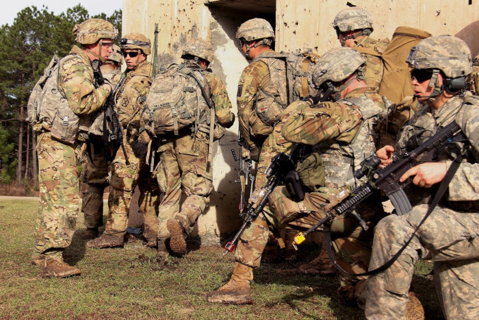 Soldiers prepare to breach a building while conducting live-fire training